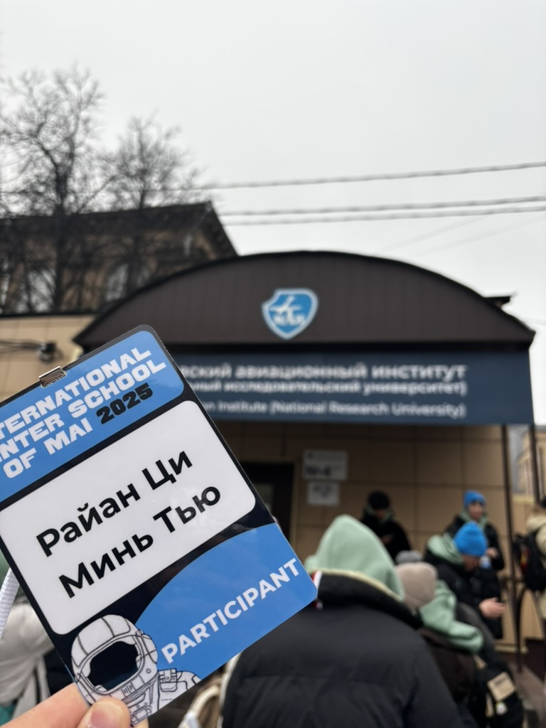 A winter school participant badge outside the Moscow Aviation Institute entrance