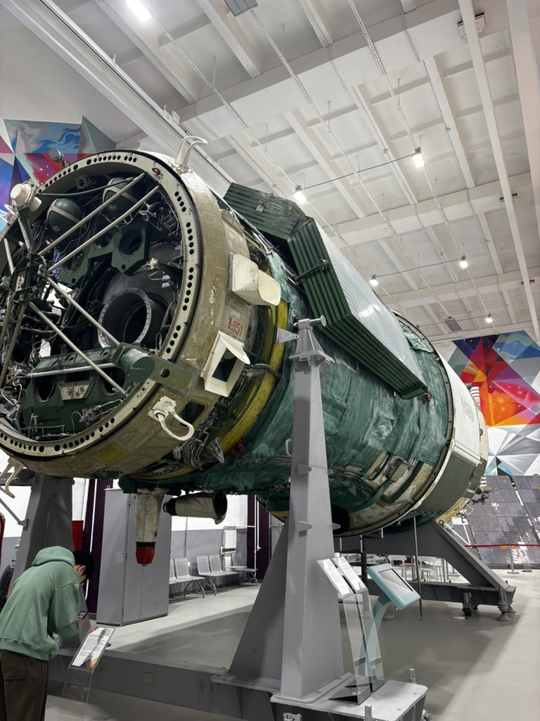 A large cylindrical spacecraft exhibit in an exhibition hall