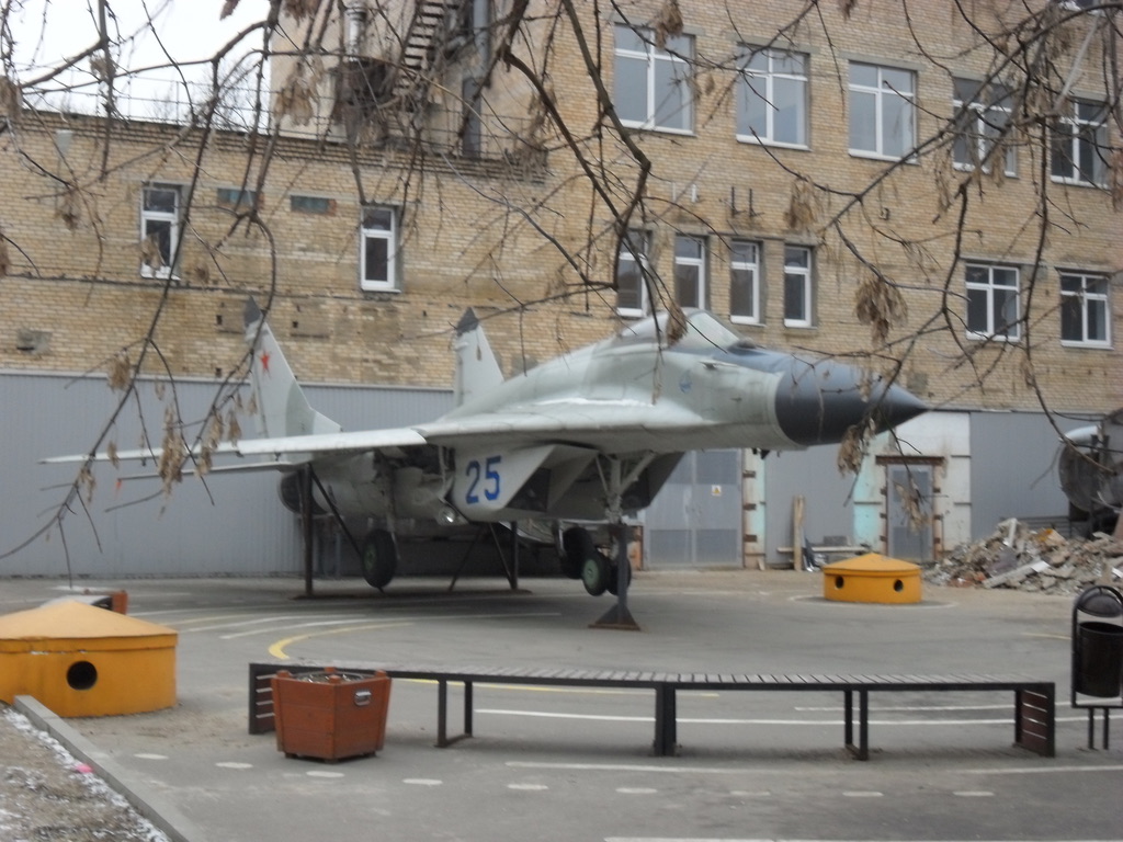 An aircraft on outdoor display beside campus buildings