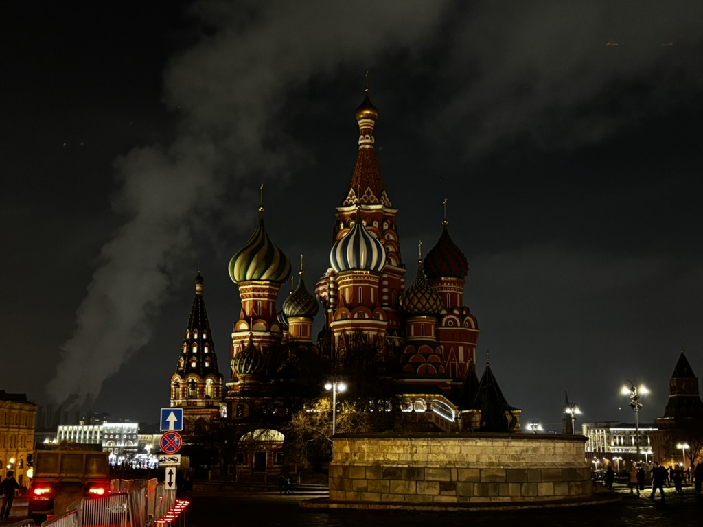 An illuminated cathedral with colorful domes at night
