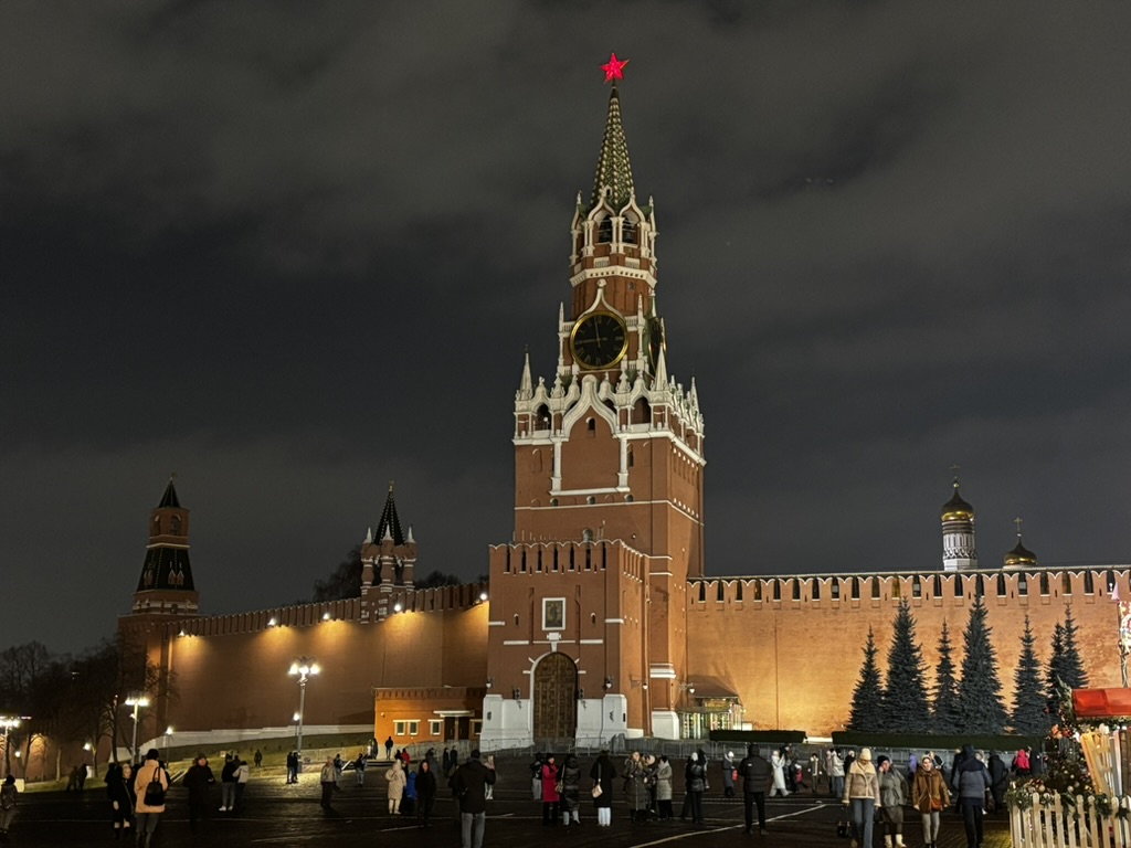 An illuminated clock tower and walls in Moscow at night