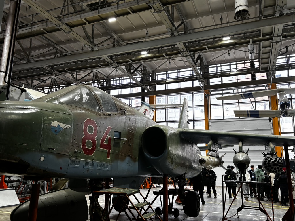 Participants studying an aircraft inside a hangar