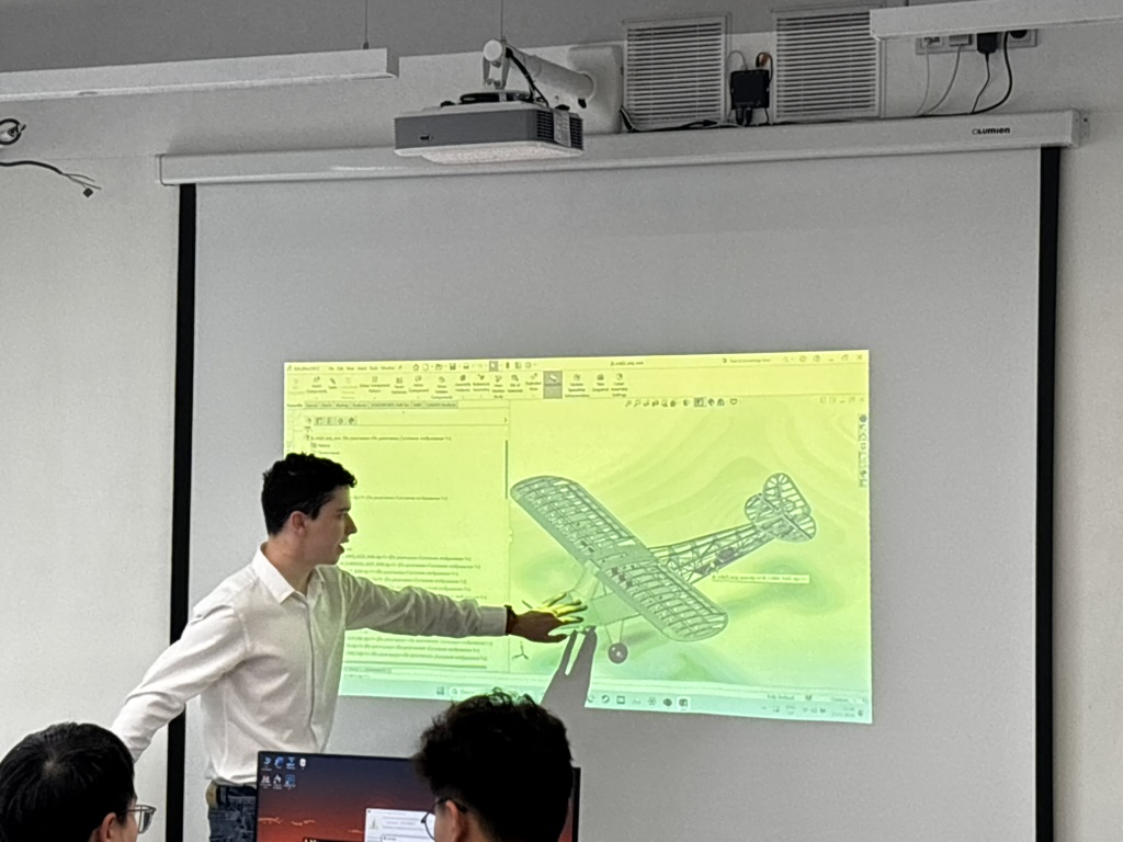 An instructor explaining an aircraft model projected in a classroom