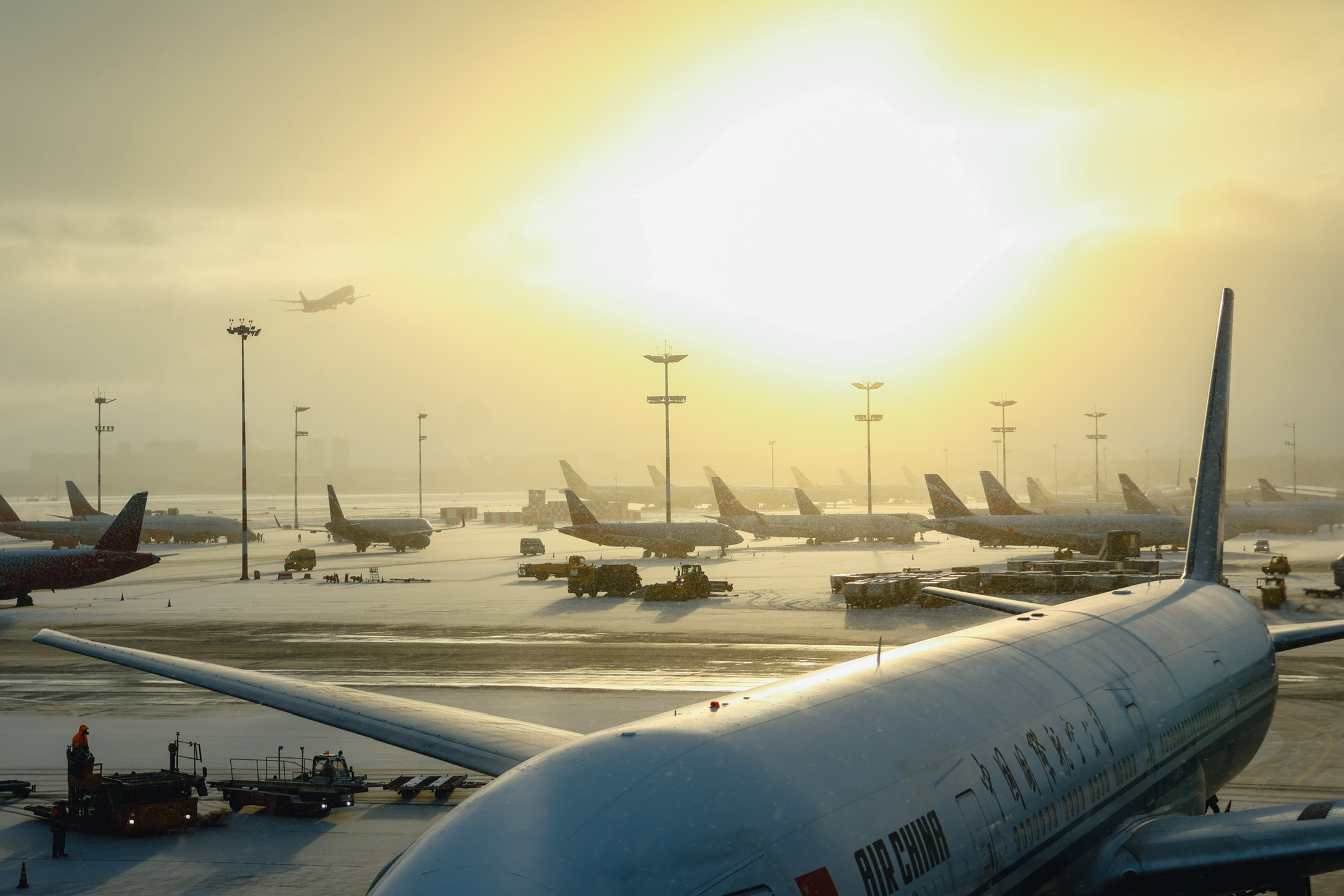 Aircraft on a snowy airport apron in sunlight