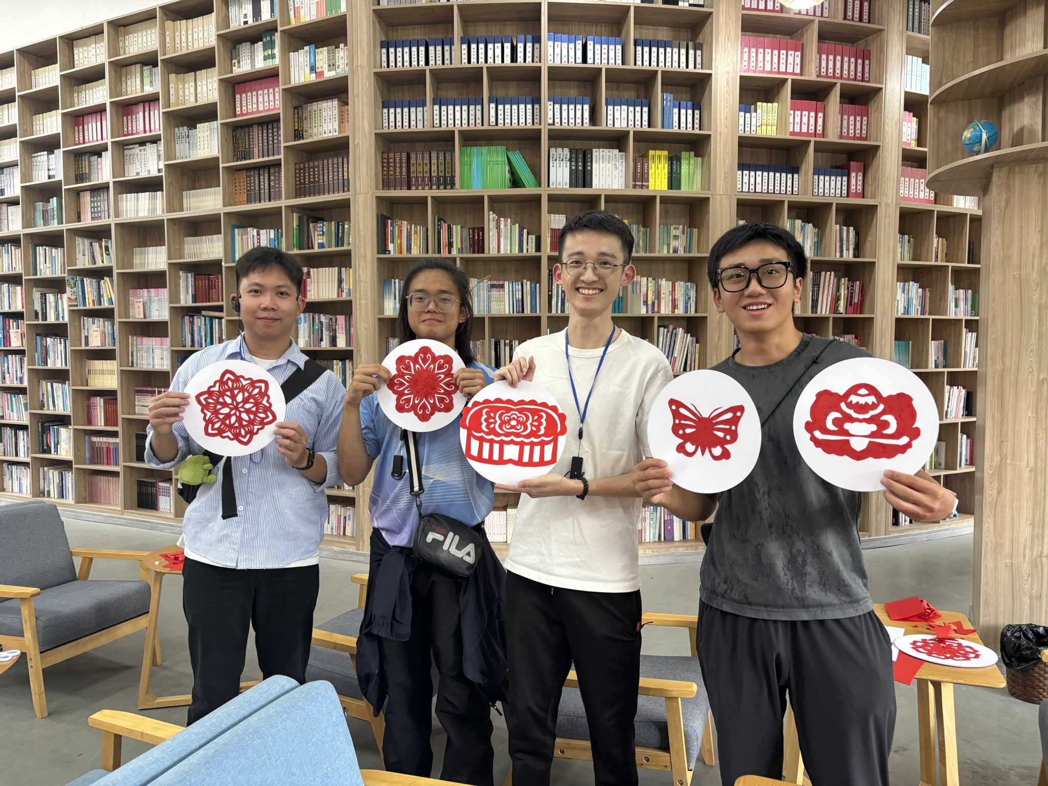 Participants displaying their paper-cut artwork in a library